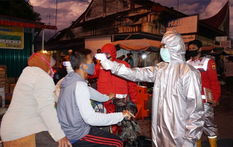 Petugas PMI Kota Pariaman memeriksa suhu tubuh pengunjung yang masuk Pasar Pariaman, Kamis (7/5/2020).