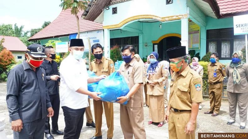 Bupati Dharmasraya, Sutan Riska Tuanku Kerajaan, bersama Ketua DPRD Paryanto,  Senin (18/5) menyerahkan bantuan masker. (Foto: IST)