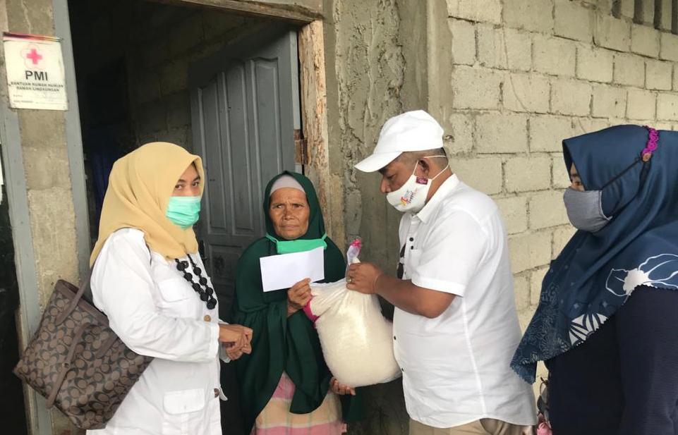 Tim AR Center, Nurhaida menyerahkan bantuan beras dan uang tunai dari Andre Rosiade untuk keluarga Anizar di Pauh, Kota Padang.
