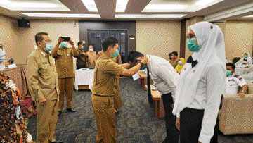 Asisten III Setko Padang Didi Aryadi secara simbolis memasangkan kokarde kepada salah seorang peserta latsar, kemarin (16/3). (IST)