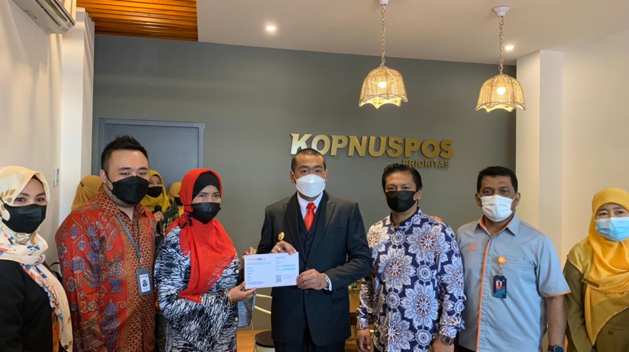 Wagub Sumbar Audy Joinaldy didampingi Kepala Kantor Utama Rumah Kopnuspos Prioritas Cabang Padang Raja Indra menyerahkan simpanan berjangka kepada anggota Kopnuspos usai peresmian Rumah Kopnuspos Prioritas Cabang Padang, kemarin (26/4). (IST)