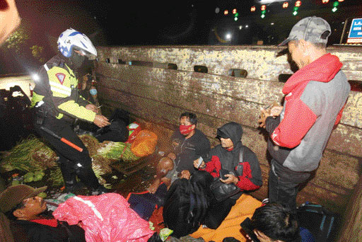 Petugas Kepolisan menahan truk bermuatan sayur yang membawa pemudik saat melintas di check point penyekatan arus mudik di Tol Cikarang Barat, Kabupaten Bekasi,  Jawa Barat, kemarin (6/5). (jgp)