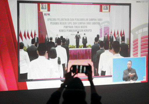 Seorang jurnalis memotret layar yang menampilkan prosesi pelantikan pegawai KPK menjadi Aparatur Sipil  Negara (ASN)  di gedung KPK, Jakarta, kemarin  (1/6). (jpg)