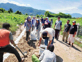 BERSEMANGAT: Warga Kelurahan Lubukbuaya bergotong royong mengerjakan program manunggal BBGRM tahun 2021.(RANDI/PADEK)