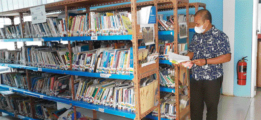 NIHIL KUNJUNGAN: Kepala Dinas Perpustakaan dan Arsip Solsel Yalasri saat memeriksa buku walau tidak ada pengunjung.(ARDI/PADEK)