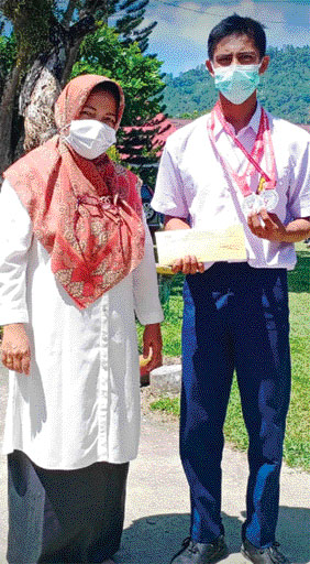 APRESIASI: Kepala SMPN 1 Tanjung Emas Genta Arni memberikan reward kepada Arinaldi Putra yang berhasil meraih medali emas dan perak dalam kejuaraan Nasional Kempo tingkat nasional.(MUSTAFA AKMAL/PADEK)