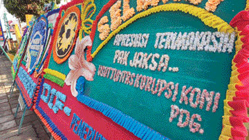 DUKUNGAN: Karangan bunga berisi dukungan pengusutan secara tuntas dugaan korupsi dana hibah KONI Padang terpajang di depan Kantor Kejari Padang, Selasa (26/10).(INDRA/PADEK)