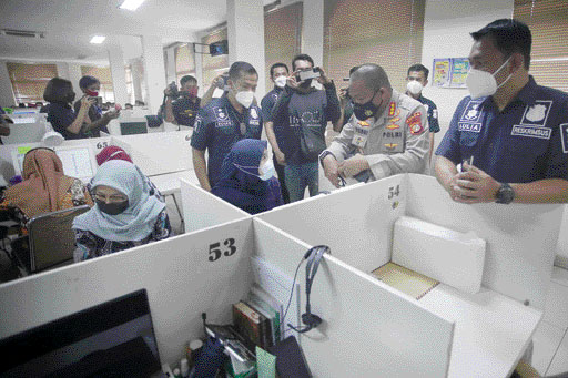 Kabid Humas Polda Metro Jaya Kombes Pol Yusri Yunus (kedua kanan) bersama Dirkrimsus Kombes Pol Auliansyah Lubis (kanan) melihat langsung pekerja jasa pinjaman online (Pinjol) menagih nasabah yang berhutang usai penggerebekan kantor jasa pinjaman online y