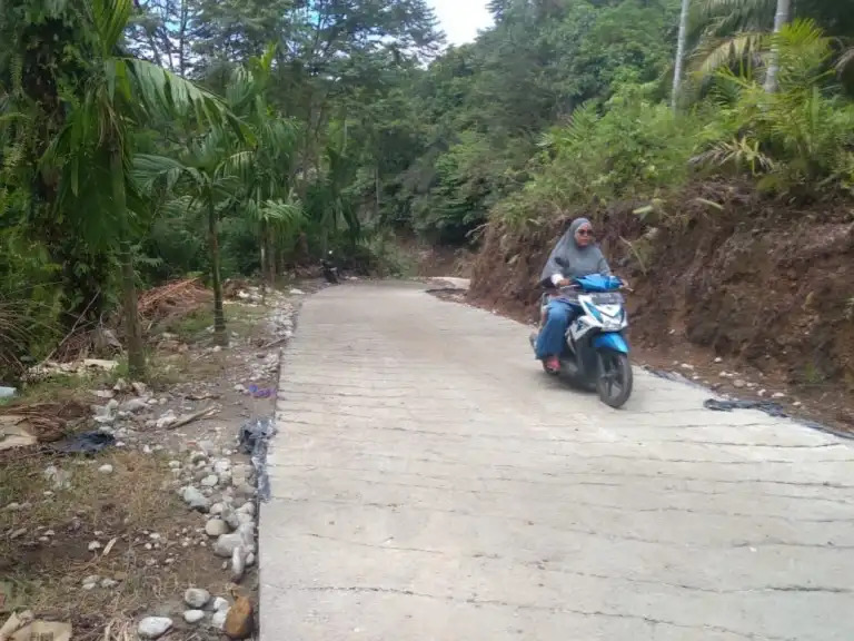 Warga melintas di jalan rabat beton yang dibangun oleh Satgas TMMD ke-112 Kodim 0304/Agam, Senin (11/10/2021).