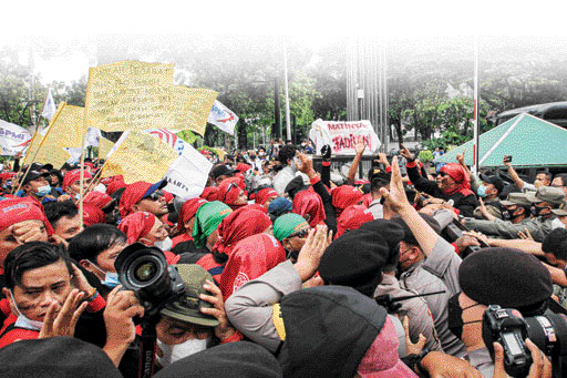 Sejumlah buruh mencoba menerobos pagar saat melakukan aksi unjuk rasa menolak upah minimum provinsi (UMP) di depan Balaikota DKI Jakarta, Senin (29/11/2021). Mereka menolak UMP DKI Jakarta yang hanya naik Rp37.749 atau sekitar 0,8 persen saja dibandingkan