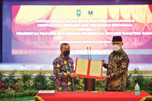 KERJA SAMA: Gubernur Sumbar Mahyeldi Ansharullah dan Gubernur Riau Syamsuar memperlihat bukti perjanjian kerja sama.(IST)