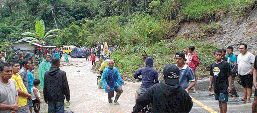 TERTIMBUN LONGSOR: Masyarakat membantu menyingkirkan material tanah longsor yang menimbun badan jalan nasional di Pakan Rabaa, Solsel, kemarin (1/11). (Bawah) aparat TNI bersama warga membersihkan sisa banjir bandang di Dharmasraya.(ARDITONO/PADEK)