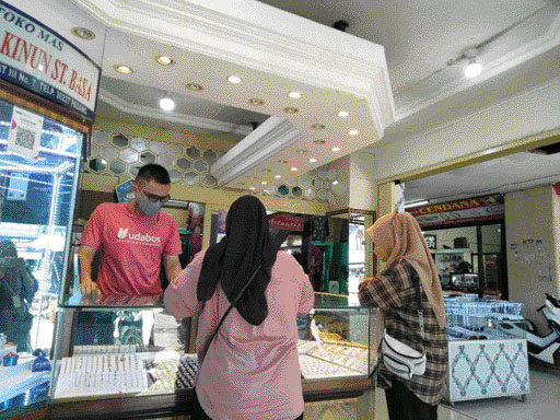 MULAI TURUN: Pedagang emas di Pasar Raya Padang tengah melayani pembeli. Harga emas sejak dua hari ini mulai turun.(IST)