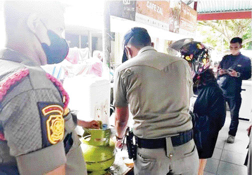 TEGURAN: Petugas Satpol PP menegur pemilik warung makan di kawasan GOR H Agus Salim yang buka di siang hari, kemarin.(IST)