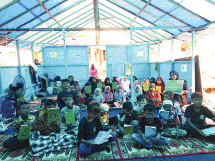BERBAGI: Anak-anak di pengungsian Kabupaten Pasbar menerima bantuan Al Quran dari IZI Sumbar dan BEM KM Unand.