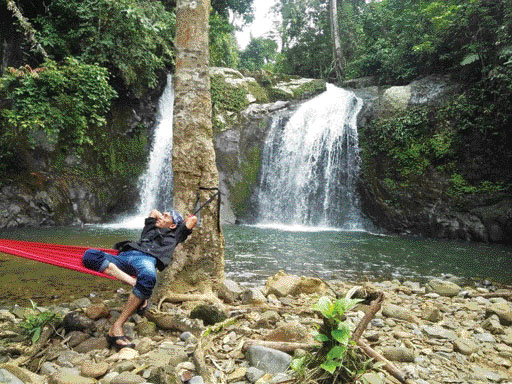 SALAH seorang pengunjung sedang menikmati suasana nyaman di Air Terjun Palano.(IST)