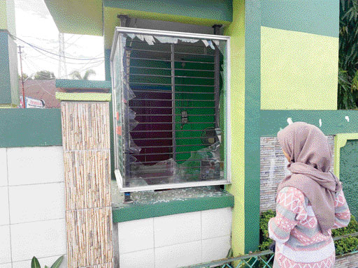 PECAH: Kondisi kaca pos penjaga SMPN 31 Padang yang pecah dilempar sekelompok remaja, Sabtu (28/5).(SHYNTIA/PADEK)