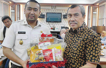 AKRAB DAN HANGAT: Wakil Gubernur Sumbar Audy Joinaldy dan Gubernur Riau Syamsuar (kanan) bertukar cinderamata khas masing-masing kedua daerah, di Padang, tadi malam (15/6).(SUYUDI ADRI PRATAMA/PADEK)