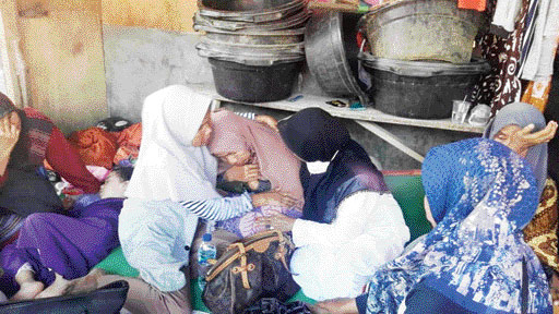 BERHARAP SEGERA DITEMUKAN: Asni (berkerudung cokelat) menangis dan bersedih mengingat putra bungsunya yang masih belum ditemukan.(SHYNTIA/PADEK)