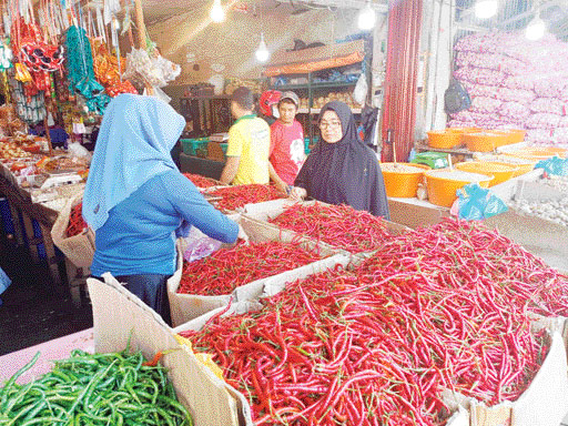 MULAI TURUN: Seorang penjual cabai di Pasar Raya Padang sedang melayani pembeli, Selasa (26/7). Harga cabai kini mulai berangsur turun.(SUYUDI/PADEK)