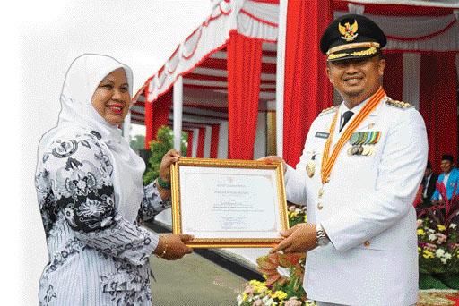 REWARD: Kepala SMAN 2 Pulaupunjung, Lindrawati menerima piagam penghargaan dari Bupati Dharmasraya, Sutan Riska Tuanku Kerajaan pada peringatan HUT ke 77 RI, Rabu (17/8).(IST)