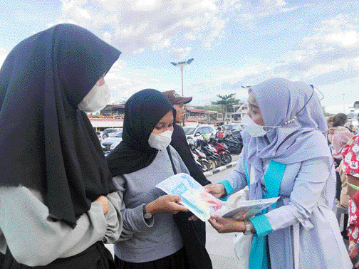 HARI PELANGGAN NASIONAL: Tim Paragon tengah mengajukan pertanyaan kepada pelanggan dan memberikan produk Emina gratis, di Pantai Purus Padang, Sabtu (3/9).(DEWI/PADEK)