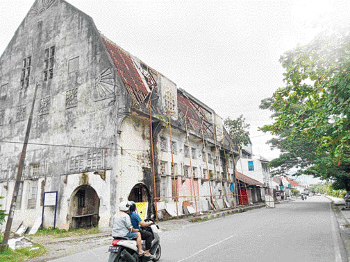 DIREVITALISASI: Seorang pengendara melintas di depan Gedung GEO Wehry & CO yang akan direvitalisasi menjadi restoran, Rabu ( 19/10).(IST)