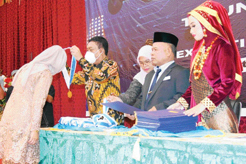WISUDA: Kepala BPSDMI Kementerian Perindustrian Arus Gunawan mengalungkan medali saat wisuda lulusan SMK SMAK Padang tahun 2022 di UPI Exhibition Hall, Rabu (12/10).(IST)