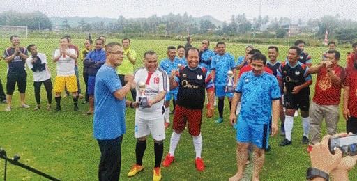 SATUKAN TEKAD: Pj Wali Kota Payakumbuh, Rida Ananda menyerahkan tropi turnamen sepakbola segitiga trofeo kepada Kadis Pendidikan Payakumbuh, Dasril.(IST)
