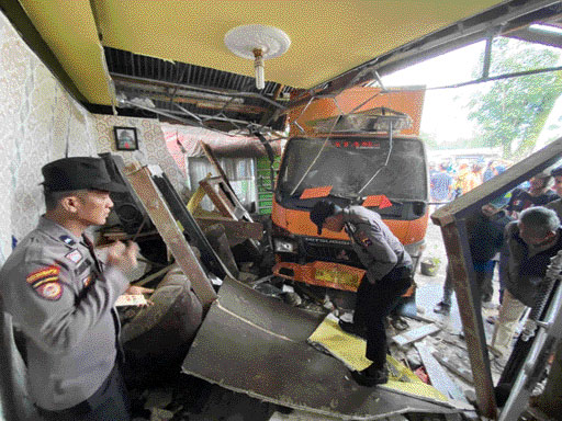 RENGGUT NYAWA: Truk box menabrak dua unit rumah warga dan menyebabkan satu orang meninggal dunia di depan Pasar Piladang, Kecamatan Akabiluru, Kabupaten Limapuluh Kota, Kamis, (24/11).(SY RIDWAN/PADEK)