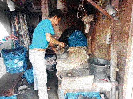 FOKUS: Darul zaman menyetrika pakaian dengan menggunakan setrika arang di kedainya, Rabu (30/11).(ANDIKA/PADEK)