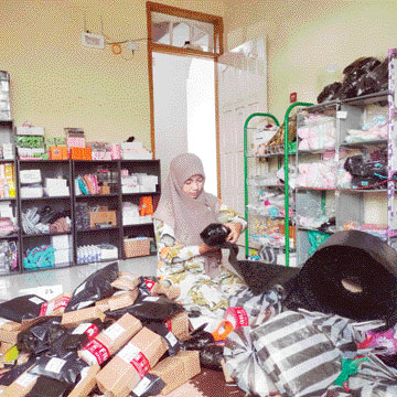 BISNIS RUMAHAN: Owner Makju Collection, Elvia Mawarni menyiapkan pesanan pelanggan bisnis online dari rumahnya, Rabu (14/12). Toko online milik Elvia menyediakan barang-barang yang terdiri dari kosmetik, aksesoris handphone, kebutuhan bayi, dan perkakas r