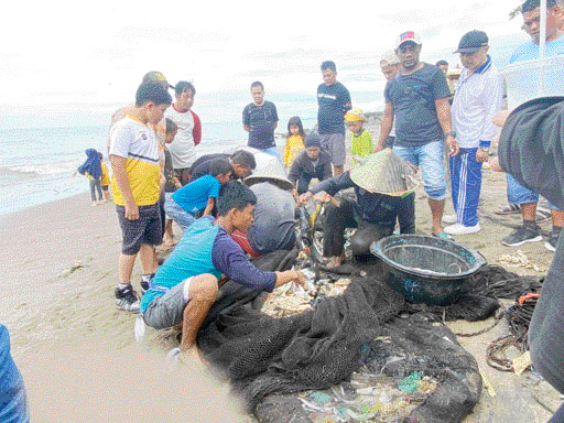 KESULITAN: Beberapa nelayan di Pantai Purus memilih ikan di antara sampah plastik yang memenuhi jaringnya, Senin (23/1).(IST)