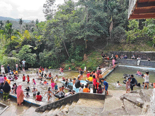 RAMAI: Ratusan pengunjung penuhi pemandian Bendungan Sontang, Kecamatan Padanggelugur, Minggu (1/1).(ANDIKA/PADEK)