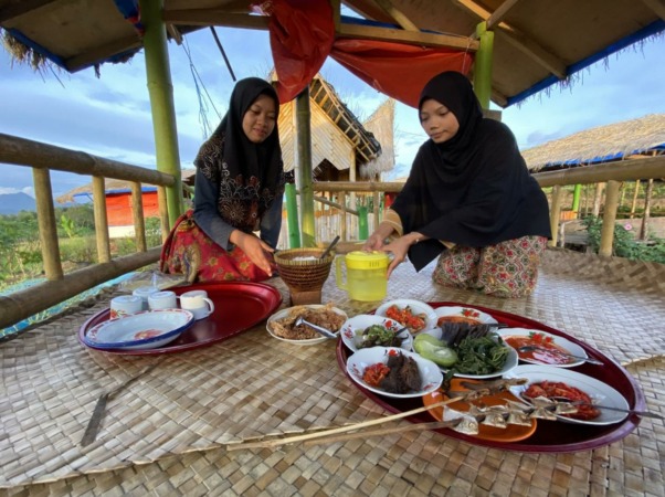 PEGAWAI Dangau Pasawangan saat membawa sejumlah makanan tradisional Minangkabau yang ditawarkan di objek wisata tersebut.(SY RIDWAN/PADEK)
