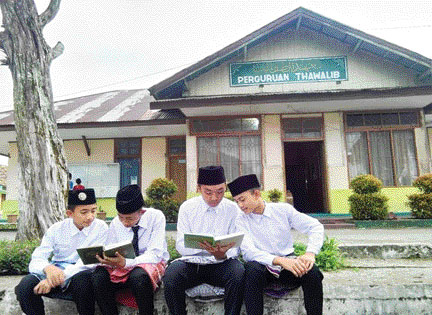 TEKUN: Sejumlah santri tengah belajar membaca kitab di sela-sela istirahat di halaman komplek Perguruan Sumatera Thawalib Padangpanjang.(IST)