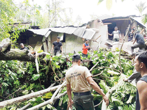 PEMBERSIHAN: Personel BPBD Kota Padang membersihkan material pohon tumbang yang menimpa dapur rumah warga di Kelurahan Bukit Gado-Gado, Kecamatan Padang Selatan, kemarin.(IST)
