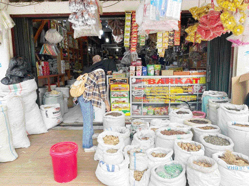 PASOKAN MENIPIS: Karyawan toko rempah- rempah melayani pembeli di Pasar Raya Padang, Senin (13/3).(TITI SATRI WAHYUNI/PADEK)