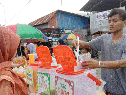 RAMAI: Pedagang takjil di Jalan Kawasan Gunungpangilun sedang melayani pembeli, kemarin (30/3).(SARAH AULIA SEPTIHANA/PADEK)