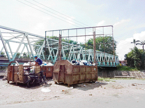 KONTAINER SAMPAH: Salah seorang pemulung sedang memilah sampah yang ada di dalam kontainer di Jembatan Andalas pada Rabu (29/3).(SHYNTIA/PADEK)