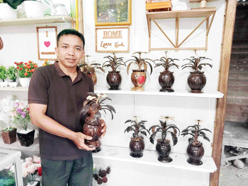 KREATIF: Ramadhona Fetra menunjukkan karya seni dari bahan limbah tempurung kelapa.(IST)