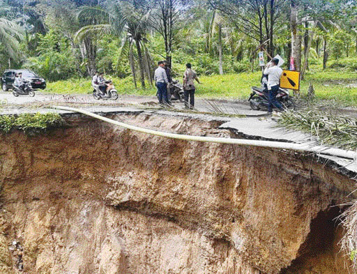 HATI-HATI: Petugas Dishub Agam sedang mengatur lalu lintas di lokasi jalan amblas penghubung Bawan-Batukambing, kemarin.