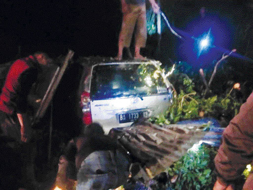 EVAKUASI: Petugas mengevakuasi material pohon tumbang yang menimpa mobil di depan Masjid Ummil Qura, Nagari Maninjau, Kecamatan Tanjungraya, Senin (27/3).(IST)
