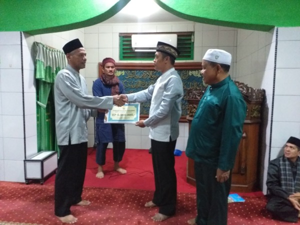 GIAT RAMADHAN: Kapolres Pariaman AKBP Abdul Aziz menyerahkan bantuan ke pengurus Masjid Mujahidin Kampung Jawa II Pariaman, dalam kegiatan safari Ramadhan, Rabu malam (29/3).(IST)