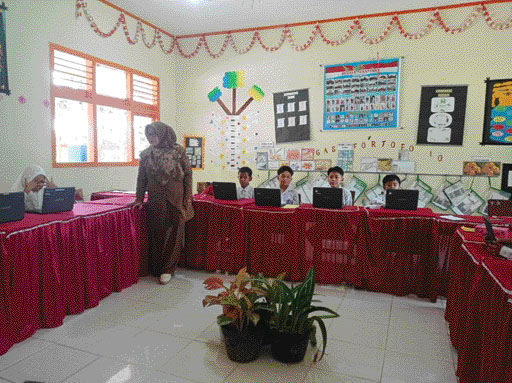MELEK TEKNOLOGI : Penulis, Surtini, S.Pd memberikan pembelajaran tentang digitalisasi kepada muridnya.(IST)
