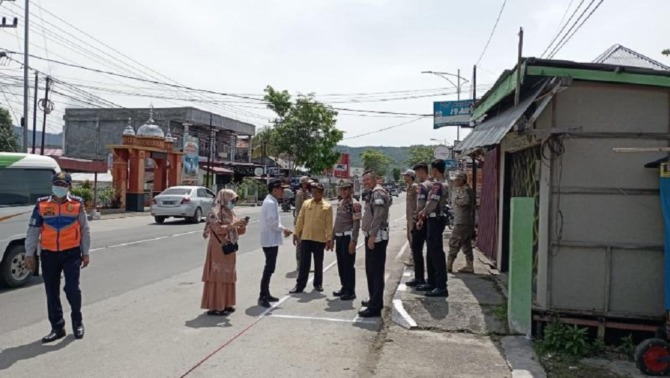 PEMBATASAN: Tim DPKUKM Kota Solok bersama kepolisian memberi tanda batas bagi pelapak yang akan berjualan di sepanjang Jalan Pandan, Senin (3/4).(IST)