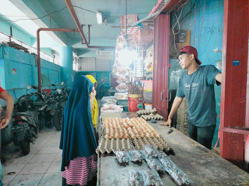 LAYANI PEMBELI: Salah seorang pedagang telur di Pasar Raya Padang sedang melayani pembeli, Minggu (21/5).(KURNIA SANDI/PADEK)