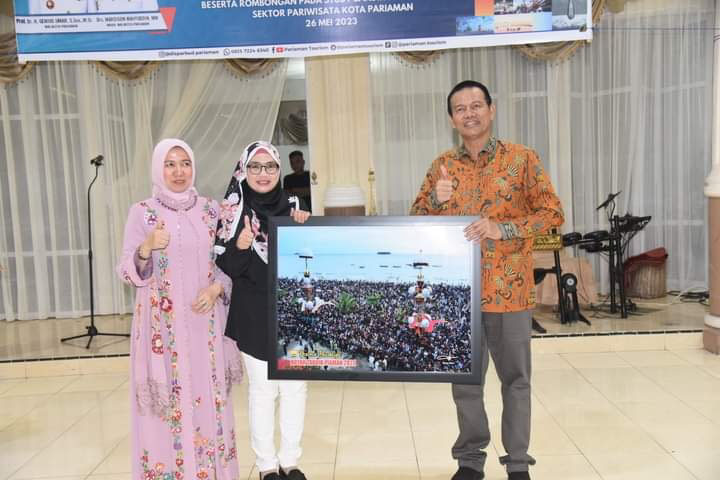 KENANG-KENANGAN: Wako Pariaman, Genius Umar, memerikan foto kegiatan Tabuik Pariaman Timbalan Mayor Kerian Perak, Malaysia, Norhafisah, yang berkunjung, Jumat (26/5).(IST)