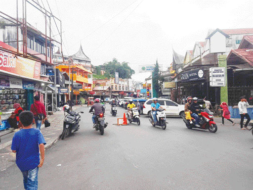 PERLU PERBAIKAN: Kondisi Jalan Perintis Kemerdekaan Bukittinggi yang berlubang dan mengganggu kelancaran lalu lintas, Minggu (21/5).(RIAN AFDOL/PADEK)