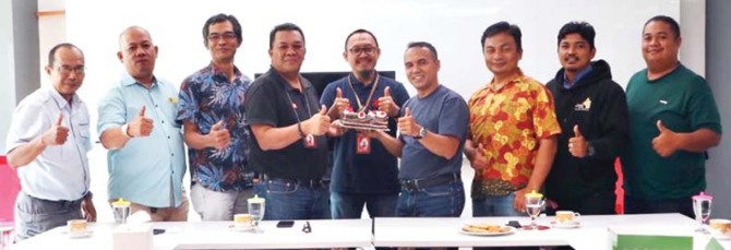 PERKUAT KERJA SAMA: Dirut Padang Ekspres Mhd Nazir Fahmi menyerahkan kue ulang tahun kepada Branch Manager Telkomsel Padang Ali Wardana disaksikan Manager Network Services Andi Suapril dan jajaran Padang Ekspres, kemarin.(SY RIDWAN/PADEK)